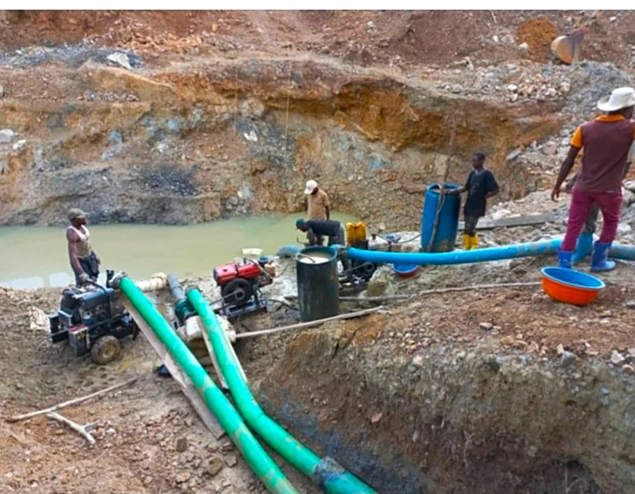 Alluvial mining pit with pumps and workers