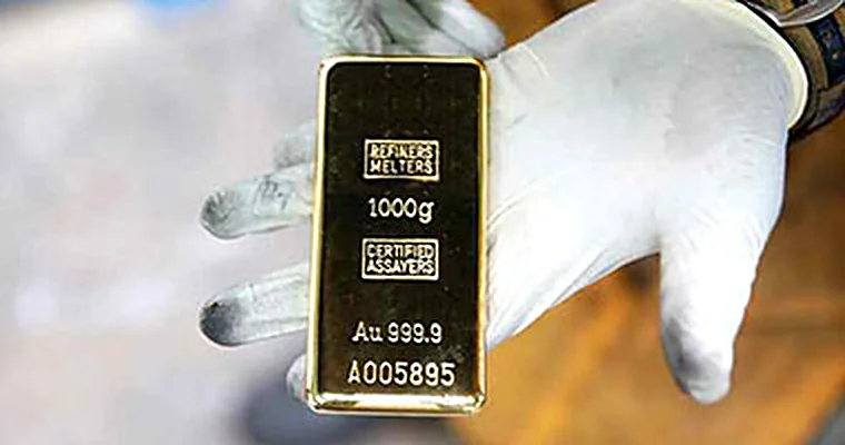 Refined 1000g Au 999.9 bar held by a gloved inspector